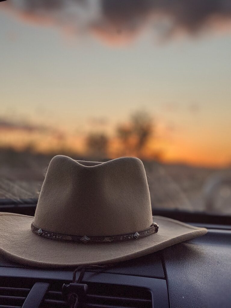 Felt hat inside of car at bright sunset